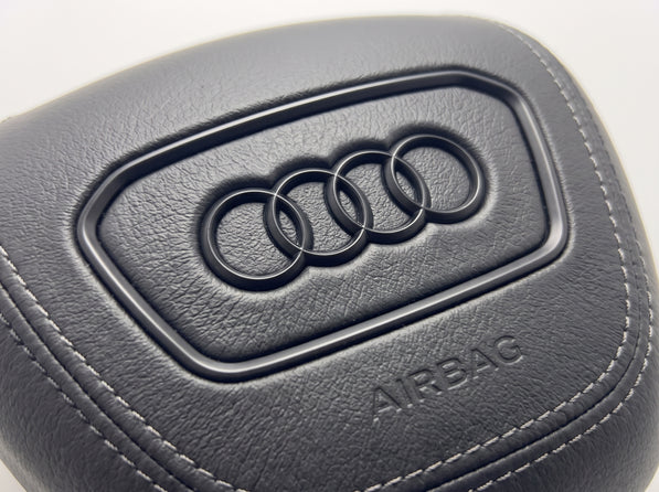 Tampa do airbag Audi 2022-2024 em pele preta lisa, pormenor do logótipo