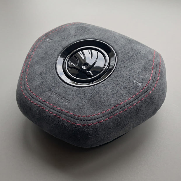 Gray Alcantara airbag cover with red stitching Skoda Fabia IV Octavia IV three-quarter view